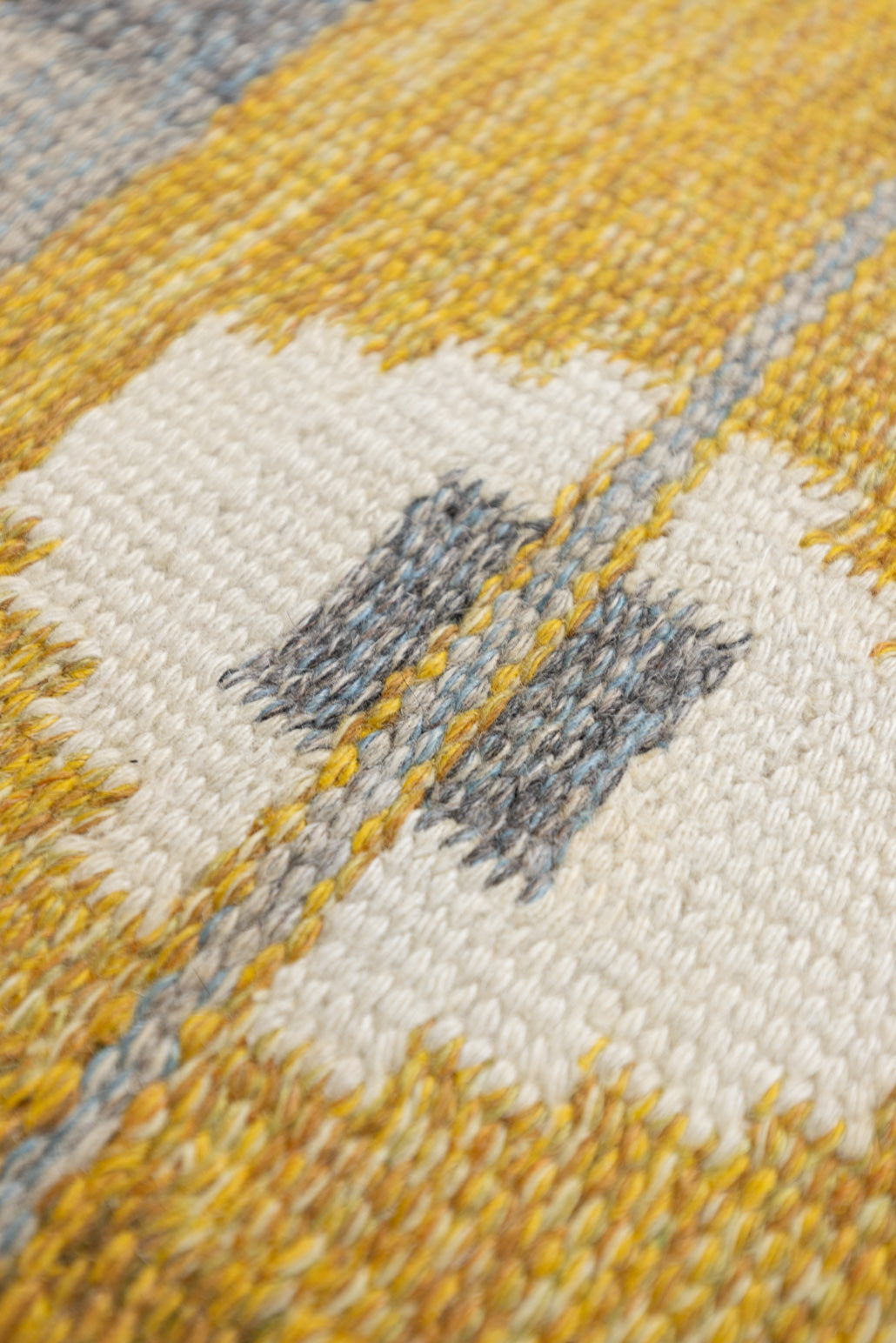 Eliza is a röllakan rug handwoven by textile designer Ingegerd Silow. Featuring a yellow, white and grey pattern