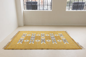 Eliza is a röllakan rug handwoven by textile designer Ingegerd Silow. Featuring a yellow, white and grey pattern