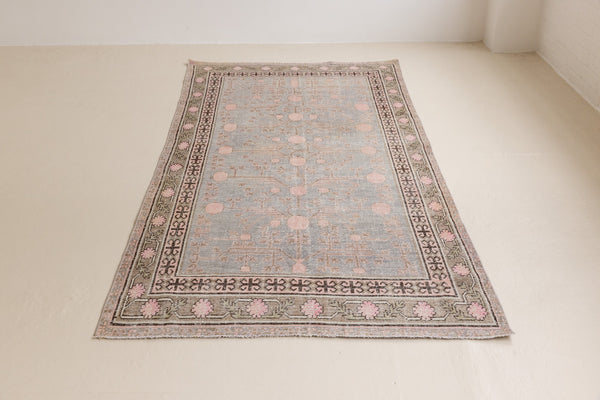 Handwoven antique Khotan carpet in soft blue, framed by a taupe and soft pink border