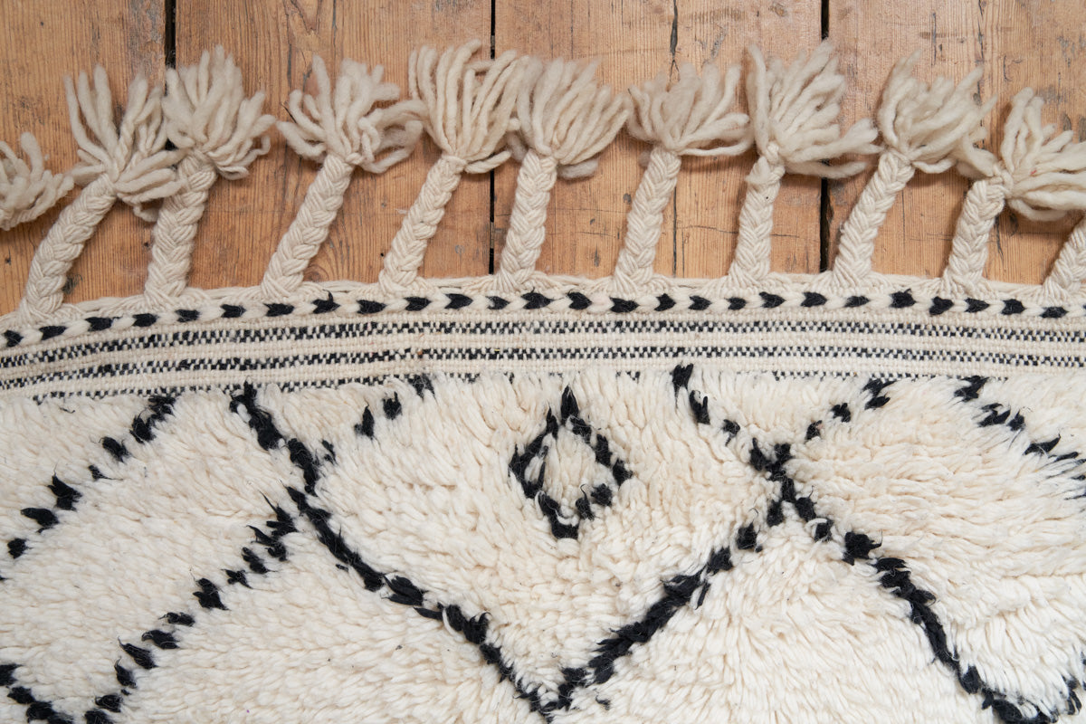 Primrose is a Beni Ourain rug with a geometric pattern, primarily beige in colour with black borders.